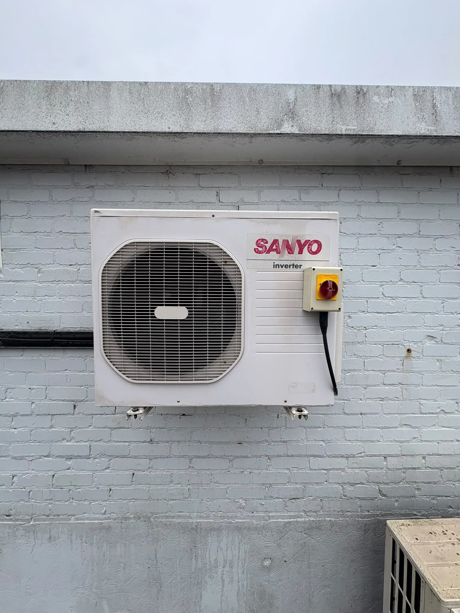 The same wall-mounted outdoor air conditioning unit after cleaning
