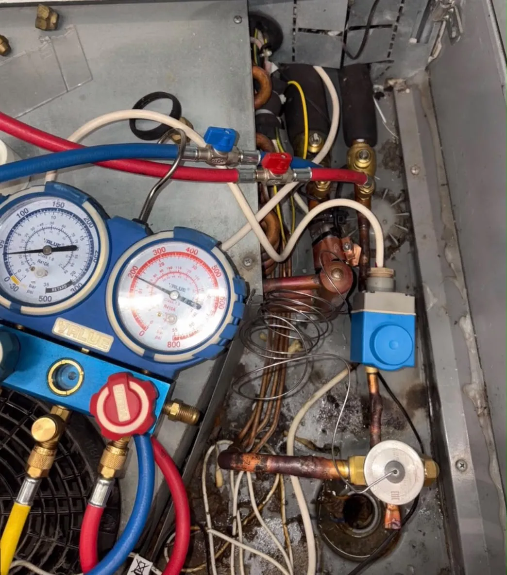 Refrigeration gauges connected to the pipework of a commercial refrigeration cabinet